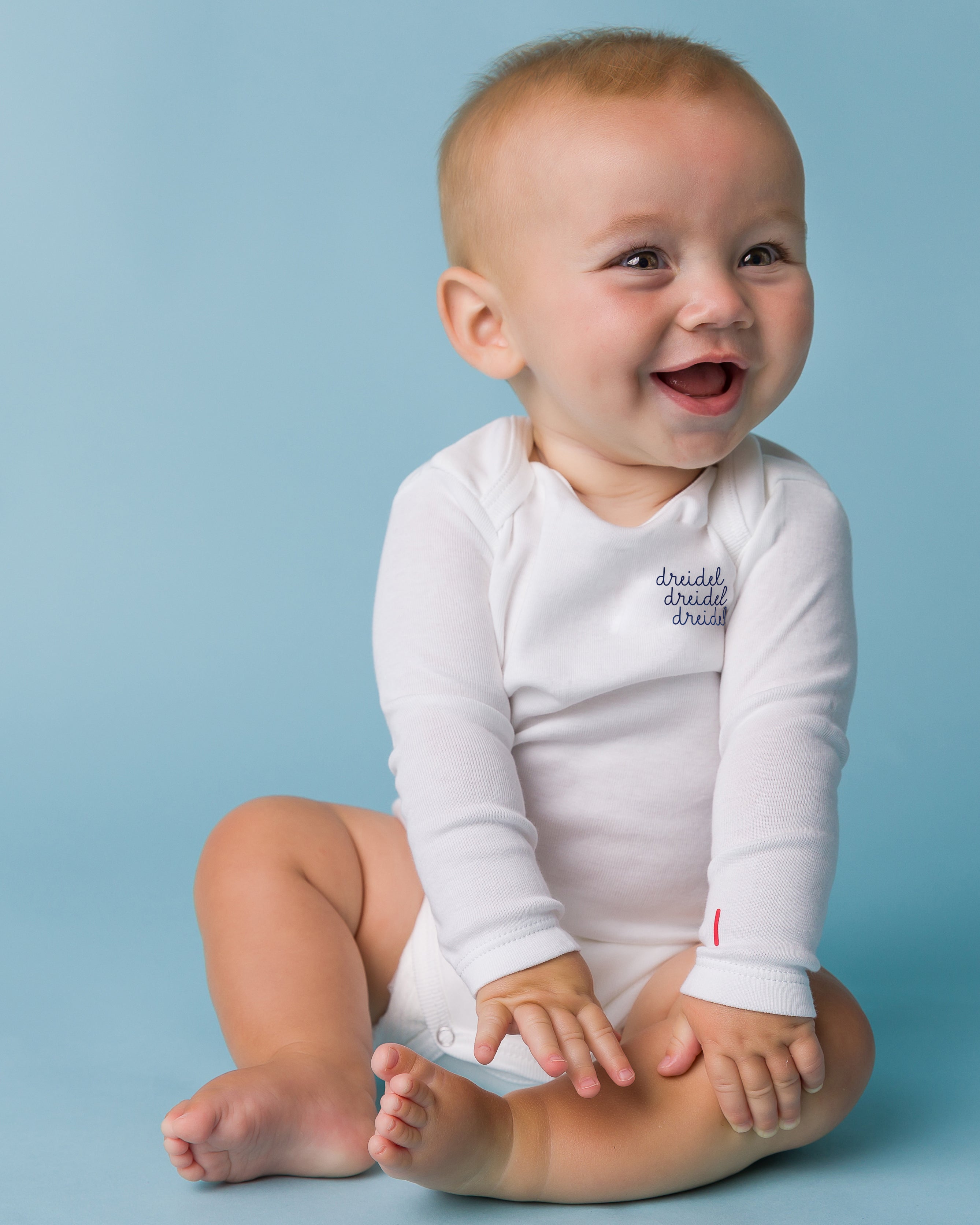 The Organic Embroidered Long Sleeve Onesie Holiday [White Dreidel Dreidel Dreidel]